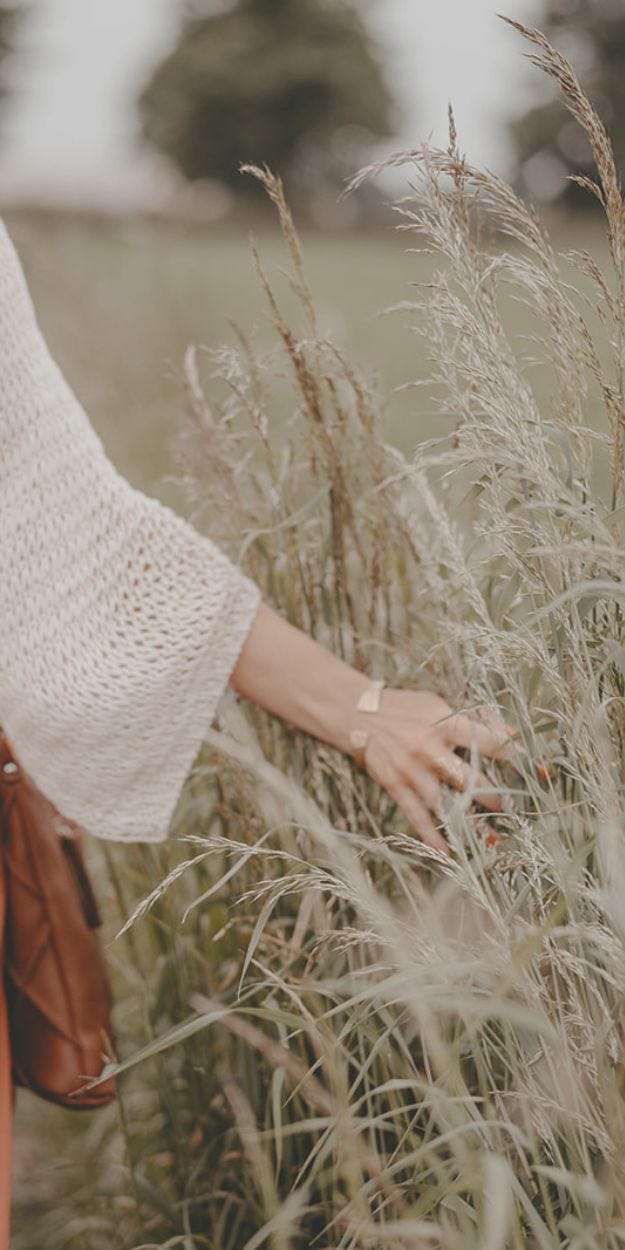 Dekoratives Bild einer Frau, die entspannt in einem Weizenfeld steht