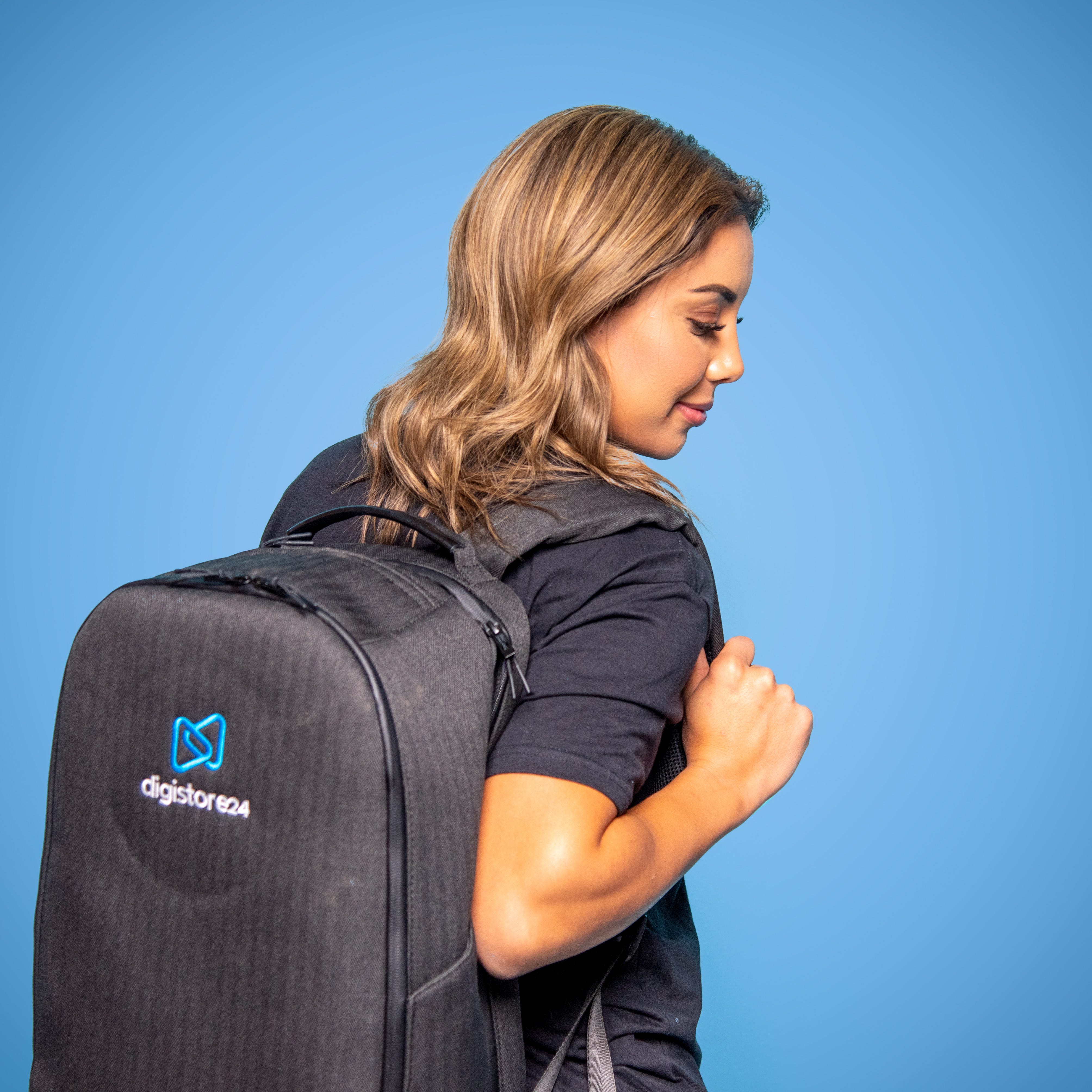 Iman wearing a Digistore24 backpack with a blue background