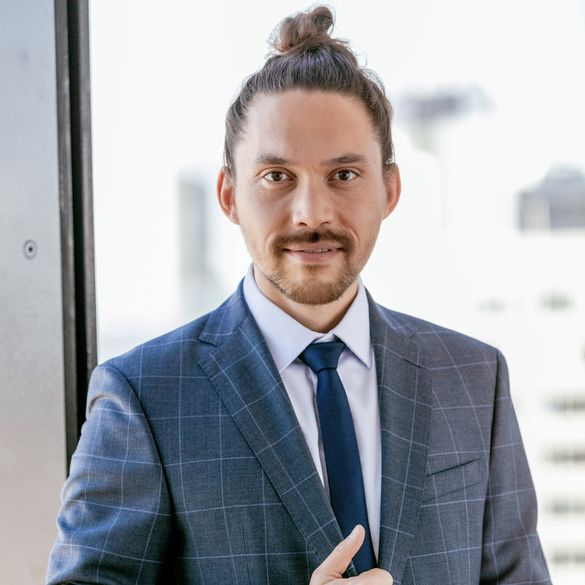 Digistore24 Founder Sven Platte holding thumb up wearing a blue checkered suit in front of window. 