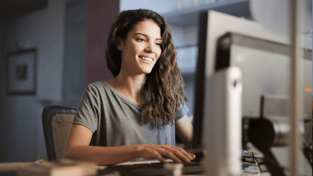 Frau sitzt lachend vor einem Computer