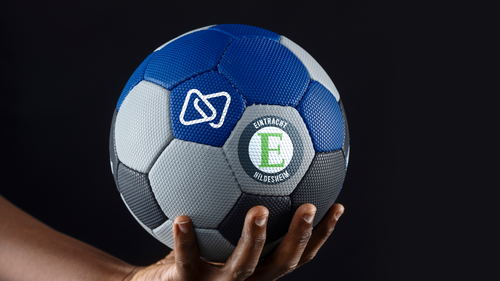 Eine Hand hält einen Handball mit den Logos von Digistore24 und dem HC Eintracht Hildesheim