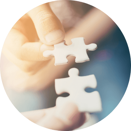 Zwei optimal zueinander passende Puzzleteile werden von den Händen einer Person zusammengefügt. Dieses Bild symbolisiert die Passgenauigkeit der Finanzplanung.