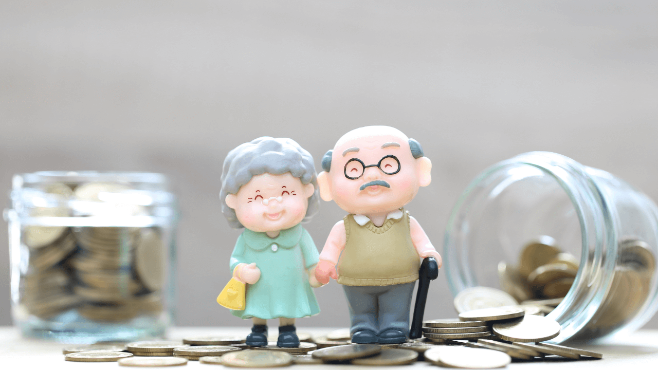 Miniaturfiguren eines älteren Paares stehen auf Münzen vor einem Geldglas, symbolisieren effektive Altersvorsorge und langfristiges Sparen.