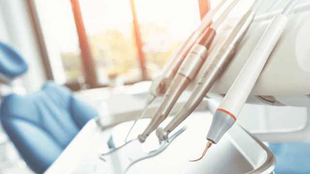 Dieses Bild zeigt eine Nahaufnahme von Zahnarztwerkzeugen, die typischerweise für Untersuchungen und Behandlungen verwendet werden. Die Instrumente sind scharf fokussiert und befinden sich auf einem Tablett, das an einem Behandlungsstuhl in einer Zahnarztpraxis angebracht ist. Die Hintergrundbeleuchtung durch das Fenster sorgt für eine helle und freundliche Atmosphäre. Das Bild vermittelt einen Eindruck von der professionellen Ausrüstung, die in der zahnmedizinischen Versorgung zum Einsatz kommt, und könnte im Kontext einer Beratung über Dentalzusatzversicherungen als visuelle Unterstützung dienen.