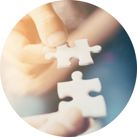 Zwei optimal zueinander passende Puzzleteile werden von den Händen einer Person zusammengefügt. Dieses Bild symbolisiert die Passgenauigkeit der Finanzplanung.