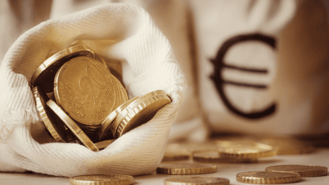 Ein offener Geldbeutel voller Euromünzen auf einem Tisch, symbolisiert effektives Sparen und Kapitalbildung für finanzielle Sicherheit und Notfallrücklagen.