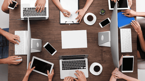 Strategisches Meeting zur Finanzplanung mit einem Team von Experten, das verschiedene Geräte wie Laptops und Tablets verwendet, um effiziente Finanzstrategien zu entwickeln und zu diskutieren, perfekt für professionelle Finanzberatung und Teamwork.