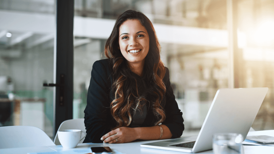 Junge Berufseinsteigerin im modernen Büro – motiviert und selbstbewusst auf dem Weg zur finanziellen Unabhängigkeit mit professioneller Finanzberatung für Frauen.