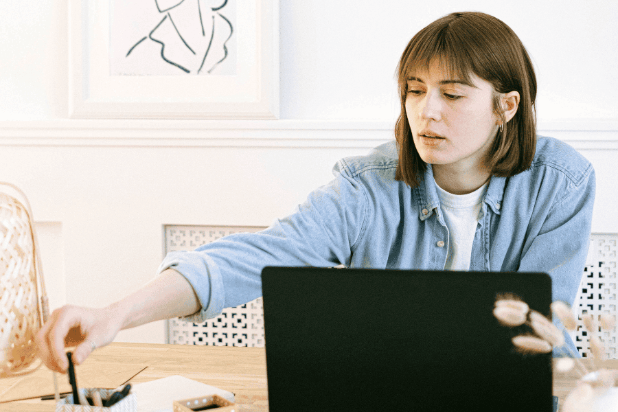 Junge Frau im Homeoffice bei der Finanzanalyse am Laptop – moderne Arbeitsweise einer Fondsmanagerin oder Investmentberaterin mit Fokus auf digitale Geldanlage.