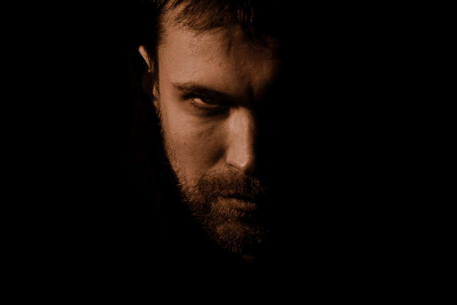 Symbolbild für Vorurteile und Misstrauen gegenüber Finanzberatung – bedrohlich wirkender Mann im Schatten als Metapher für unseriöse Methoden in der Finanzbranche.