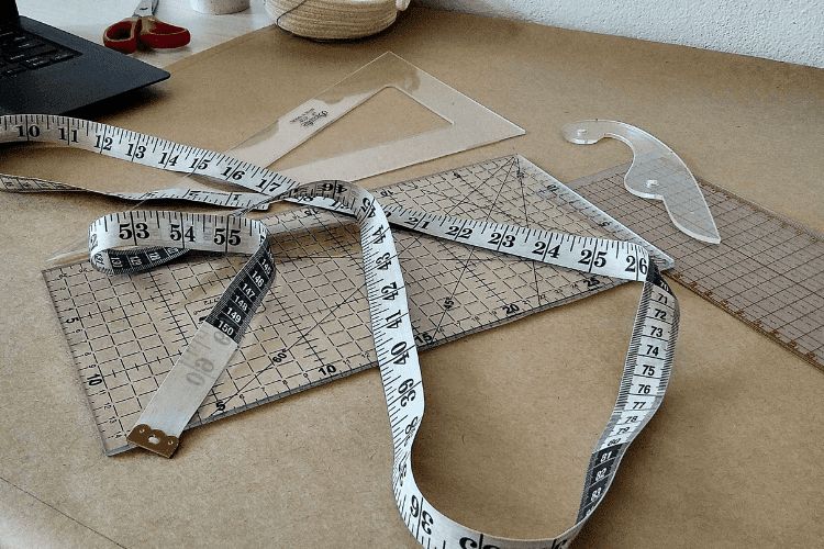 Maßband und Schnittmuster als Symbol für eine maßgeschneiderte Geldanlage und individuelle Anlagestrategie passend zu persönlichen Zielen und Risikoprofil.