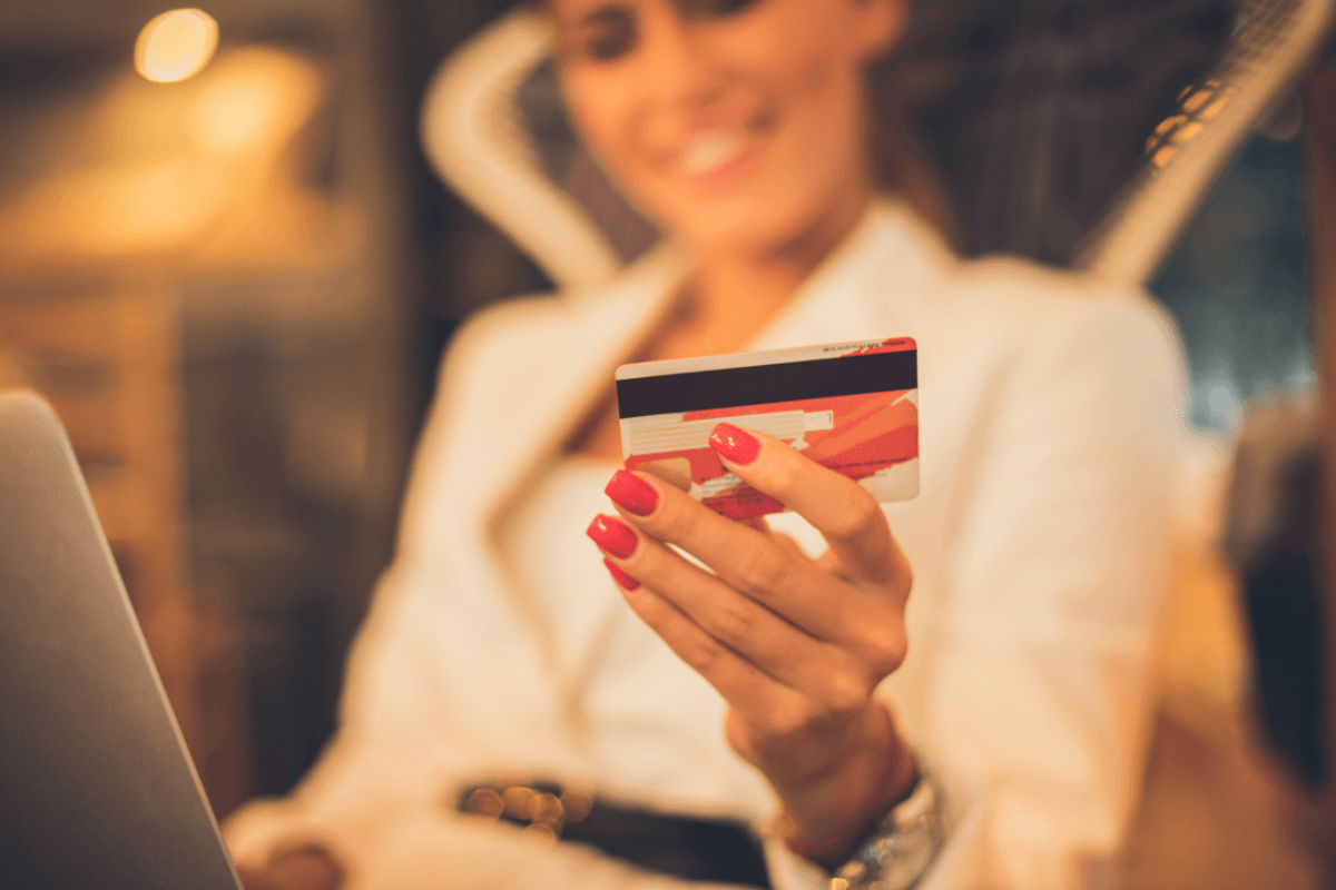 Frau beim Online-Shopping mit Kreditkarte als Symbol für Lifestyle-Inflation, bewussten Umgang mit Geld und Cashflow-Management durch ein Kontenmodell.